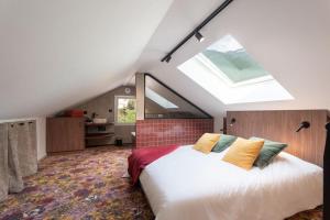 a bedroom with a large bed with a skylight at L'Entre Nous Climatisation Terrasse in Saint Avre la Chambre