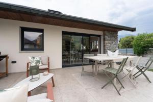a patio with a table and chairs on a patio at L'Entre Nous Climatisation Terrasse in Saint Avre la Chambre