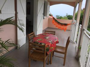 a table and chairs on the porch of a house at Villa Hibiscus in Bouillante