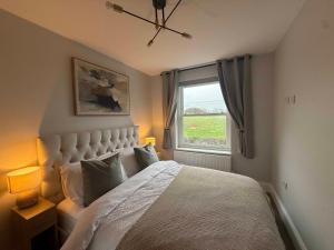 a bedroom with a large bed and a window at Castle Mount Apartments in Sandal and Walton