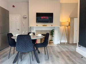 a dining room with a table and chairs and a tv at Castle Mount Apartments in Sandal and Walton