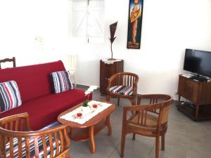 a living room with a red couch and chairs at Villa Hibiscus in Bouillante