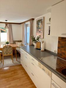 a kitchen with white cabinets and a dining room at Ferienwohnung Lauterach in Lauterach