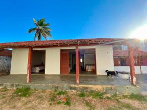 a dog standing in front of a house at Pousada Casa Atlântica in Luis Correia