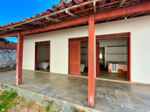 a house with red columns and a patio at Pousada Casa Atlântica in Luis Correia