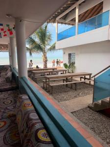 a building with picnic tables on the beach at hostal EMBAMAR in Palomino