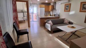 a living room with a couch and a table and a kitchen at Apartamento Lola 1 in Nerja