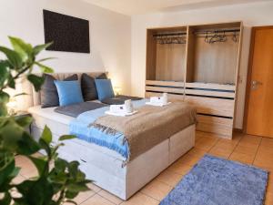 a bedroom with a large bed with blue pillows at Faraway Homes Studios Eberstalzell in Eberstalzell
