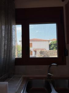 a kitchen with a sink and a window with a view at Maronia Villa in Maronia