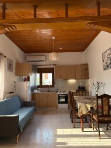 a kitchen with a table and a blue couch at Maronia Villa in Maronia