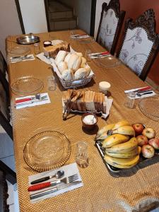 a table with a bunch of bread and fruit on it at Hospedaria Allecrim in Santo André
