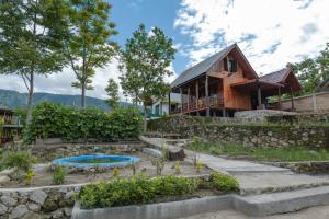 a house with a garden and a pool in front of it at The Wood Cabin in Ambarita