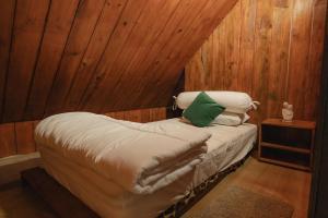 a small bed in a room with wooden walls at The Wood Cabin in Ambarita