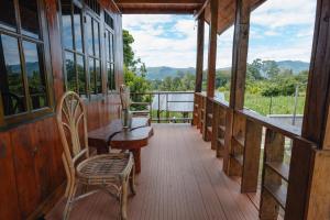 a porch of a cabin with a table and chairs at The Wood Cabin in Ambarita