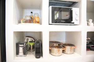 a kitchen with a microwave and various kitchen appliances at Off the beaten path! Maisonette & Pool in Kithnos +53 photos