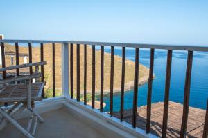 a balcony with a chair and the ocean at Off the beaten path! Maisonette & Pool in Kithnos