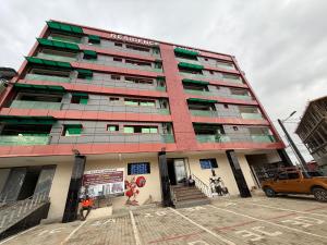 a tall building with a parking lot in front of it at Résidence sauver in Abidjan