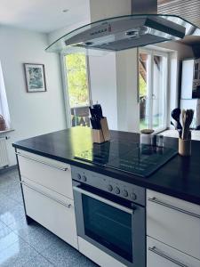a kitchen with a stove with a black counter top at Ferienapartment Naturblick in Hausen