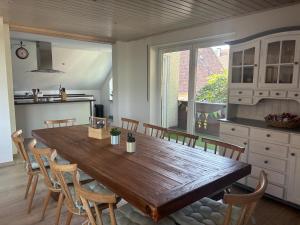 a large wooden table in a kitchen with chairs at Ferienapartment Naturblick in Hausen +13 photos