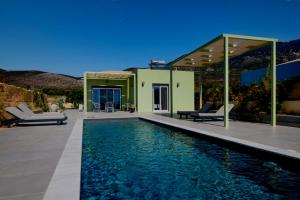 a house with a swimming pool in front of a house at MENTOROS VILLAS in Karavádhos