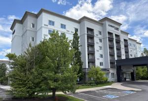 a white building with a tree in front of it at Courtyard by Marriott Toronto Markham in Markham