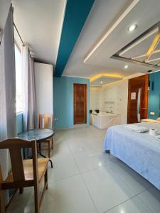 a bedroom with a bed and a table and a tub at Inti killa in Huánuco