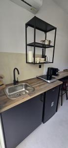 a kitchen counter with a sink and a shelf at Syros Blue Lagoon G2 in Galissas