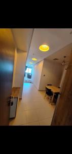 a hallway with a table and a yellow light at Location par nuitée in Oran