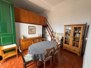 a dining room with a table and chairs and a staircase at The Hidalga's cozy house in Arafo