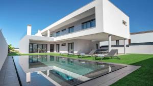 a large white house with a swimming pool at Private Alvor villa with pool and Jacuzzi in Alvor