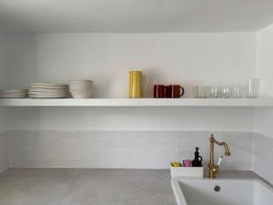 a kitchen with a sink and a shelf with dishes at The Hidalga's cozy house in Arafo +19 photos