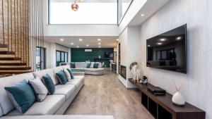 a living room with a white couch and a tv at Private Alvor villa with pool and Jacuzzi in Alvor