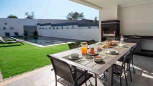 a dining room with a table in a backyard at Private Alvor villa with pool and Jacuzzi in Alvor