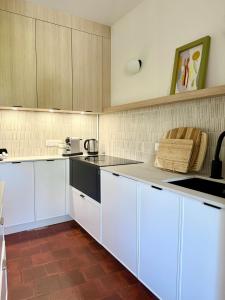 a kitchen with white cabinets and a counter top at Maison Gazel in Castres