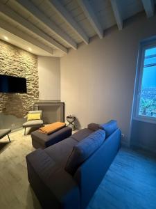 a living room with a blue couch and a tv at Maison Gazel in Castres