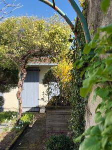 a garden with an archway in front of a garage at Maison Gazel in Castres
