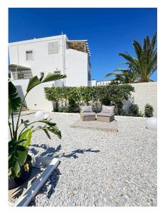 a patio with a couch and some plants and a building at Syros Blue Lagoon G2 in Galissas