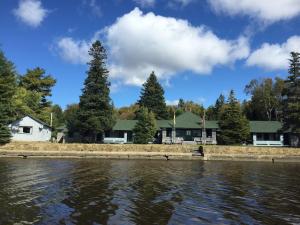 a house on the shore of a body of water at Bob's Cabin at Wishart's Point Lodge in Neguac