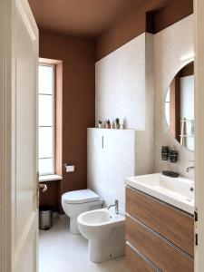 a bathroom with a toilet and a sink and a mirror at Venzone dalla Finestra in Venzone