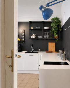 a kitchen with white cabinets and a blue light fixture at Venzone dalla Finestra in Venzone +6 photos