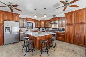 a kitchen with wooden cabinets and a island with bar stools at Sea Manor in New Smyrna Beach