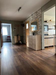 a living room with wooden floors and a kitchen at U Leona in Przeciszów