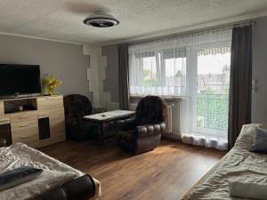 a living room with two chairs and a table and a television at U Leona in Przeciszów