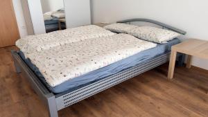a bed in a room with a wooden table at Moderní apartmán Boskovice in Boskovice