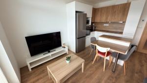 a small living room with a table and a kitchen at Moderní apartmán Boskovice in Boskovice +8 photos