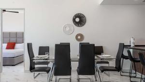 a dining room with a table and black chairs at Encantame Soleil Ground Floor Getaway in Playa Encanto
