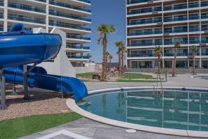 a blue water slide in front of a building at Encantame Soleil Ground Floor Getaway in Playa Encanto +34 photos