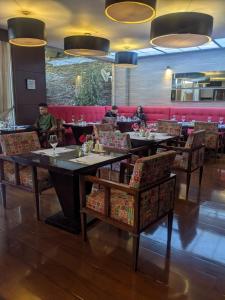 a dining room with tables and chairs and people in a restaurant at Blue Suites Hotel in Bogotá