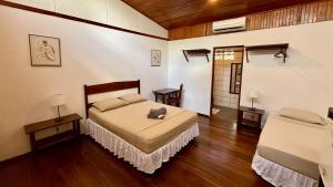 a bedroom with a bed in a room with wooden floors at El Clan Hostel in Puerto Viejo