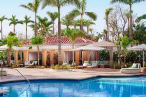 a resort with a swimming pool and palm trees at The Ritz-Carlton Naples in Naples